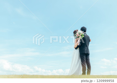 キスする空バックの新郎新婦（ウェディング・結婚式・ブライダル・ロケーションフォト） 120999958