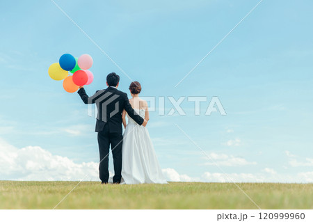 風船を持つ新郎新婦の後ろ姿（ウェディング・結婚式・ブライダル・フォトウェディング） 120999960