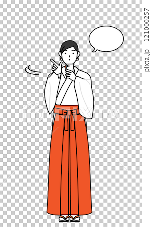 A shrine maiden in a white robe and scarlet hakama operating a smartphone 121000257
