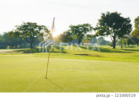 Landscape of putting green in golf course. Asian male amateur golfer is enjoy playing golf at golf course in morning, he is showing his beautiful swing during tee off. Man playing golf. 121000519