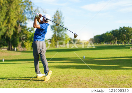 Asian male amateur golfer is enjoy playing golf at golf course in morning, he is showing his beautiful swing during tee off. Man playing golf. Asian male amateur golfer is enjoy playing golf at golf course in morning, he is showing his beautiful swing during tee off. Man playing golf. 121000520