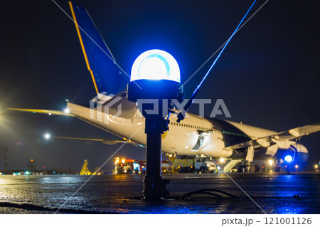 Taxiway, side row lights on the background of a large passenger aircraft at the night airport apron Taxiway, side row lights on the background of a large passenger aircraft at the night airport apron 121001126