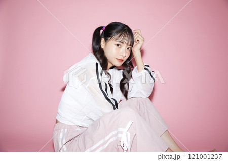 ピンク背景で撮影をしたスポーティな服装をした若い女性のキュートなポートレート ピンク背景で撮影をしたスポーティな服装をした若い女性のキュートなポートレート 121001237