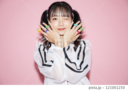 ピンク背景で撮影をしたスポーティな服装をした若い女性のキュートなポートレート ピンク背景で撮影をしたスポーティな服装をした若い女性のキュートなポートレート 121001250