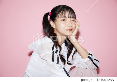 ピンク背景で撮影をしたスポーティな服装をした若い女性のキュートなポートレート ピンク背景で撮影をしたスポーティな服装をした若い女性のキュートなポートレート 121001255