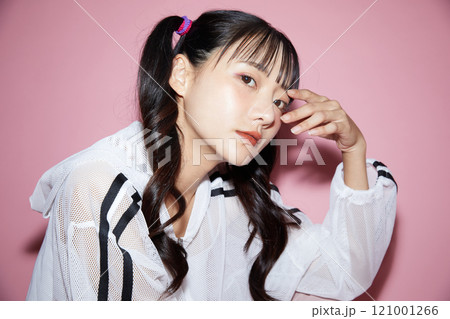 ピンク背景で撮影をしたスポーティな服装をした若い女性のキュートなポートレート ピンク背景で撮影をしたスポーティな服装をした若い女性のキュートなポートレート 121001266