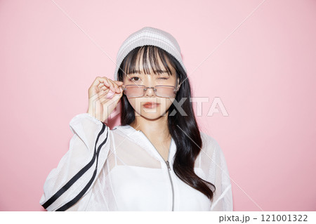 ピンク背景で撮影をしたスポーティな服装をした若い女性のキュートなポートレート 121001322