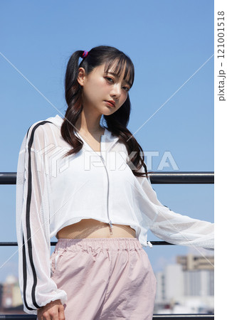 屋外で撮影をした若い女性のカジュアルでファッショナブルなポートレート 121001518