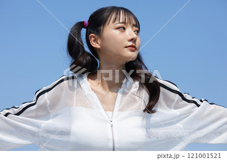 屋外で撮影をした若い女性のカジュアルでファッショナブルなポートレート 121001521