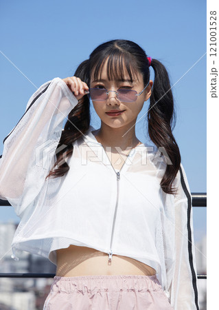 屋外で撮影をした若い女性のカジュアルでファッショナブルなポートレート 121001528
