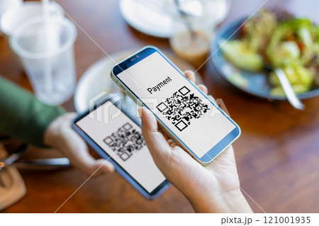 Hand using mobile phone application to scan QR code, Hands holding mobile phone, Qr code payment or cashless technology concept, Coffee shop accepting digital pay without money, Meaningless QR code. 121001935