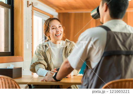 コテージ・キャビン・ログハウスでコーヒーを飲みながら笑顔で会話する夫婦 121003221