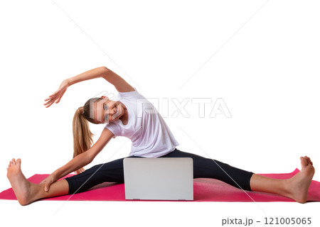 Sporty young woman sitting in pink yoga mat in white T-shirt, doing exercises, watching online yoga class on laptop computer, isolated Sporty young woman sitting in pink yoga mat in white T-shirt, doing exercises, watching online yoga class on laptop computer, isolated 121005065