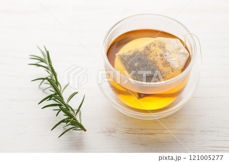 Cup of hot tea blended from rooibos, spearmint, apple, baobab on white wooden table. Cup of hot tea blended from rooibos, spearmint, apple, baobab on white wooden table. 121005277