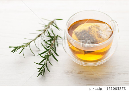 Cup of hot tea blended from rooibos, spearmint, apple, baobab on white wooden table. Cup of hot tea blended from rooibos, spearmint, apple, baobab on white wooden table. 121005278