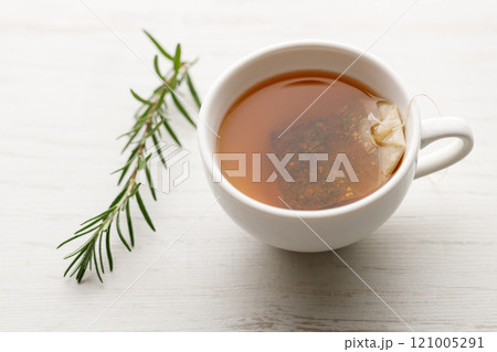 Cup of hot tea blended from rooibos, spearmint, apple, baobab on white wooden table. 121005291