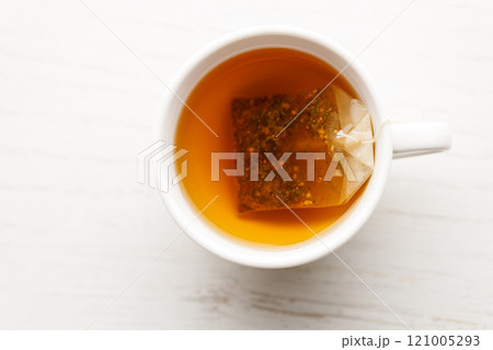 Cup of hot tea blended from rooibos, spearmint, apple, baobab on white wooden table. 121005293