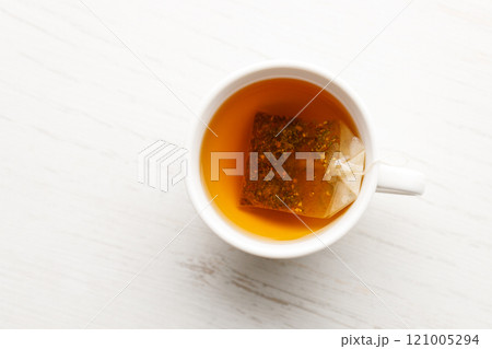 Cup of hot tea blended from rooibos, spearmint, apple, baobab on white wooden table. 121005294