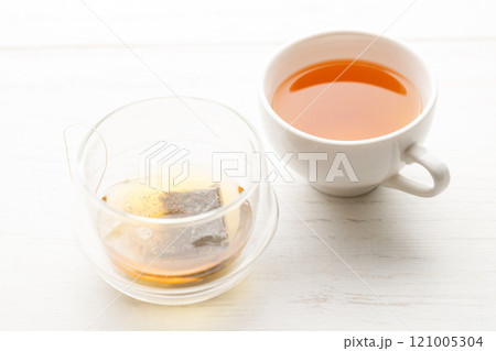 Cup of hot tea blended from rooibos, spearmint, apple, baobab on white wooden table. Cup of hot tea blended from rooibos, spearmint, apple, baobab on white wooden table. 121005304