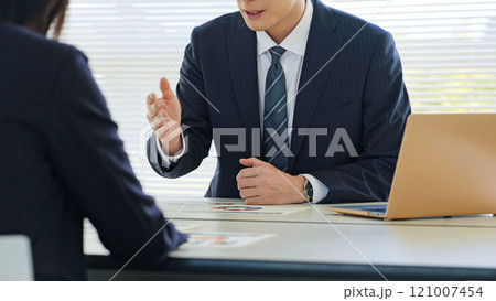 オフィスで商談するビジネスパーソンのグループ 121007454