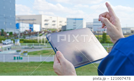 建物の前でタブレットPCを使う男性作業員 121007478