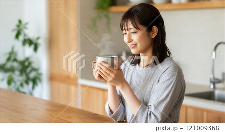 ホットドリンクを飲みほっとする女性 121009368
