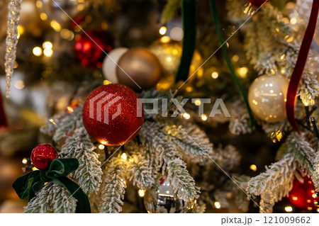 A vibrant red disco ball is beautifully hanging from a christmas tree A vibrant red disco ball is beautifully hanging from a christmas tree 121009662