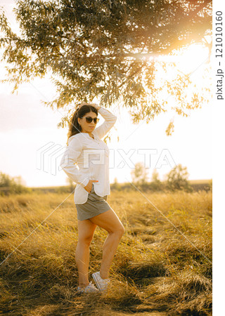Young beautiful woman with long hair. Summer day. Full length portrait in the park. 121010160