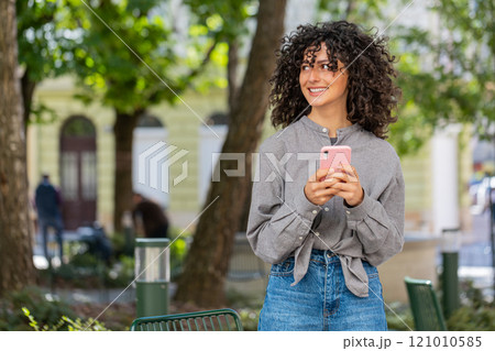 Caucasian young woman using smartphone typing text messages in social media application online 121010585