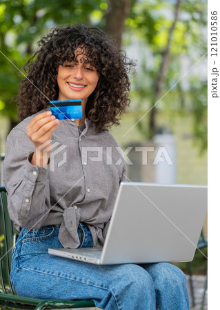 Caucasian young woman using credit bank card and laptop transferring money purchases online shopping 121010586