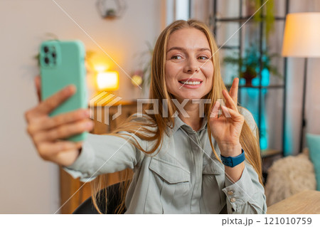 Caucasian mature woman freelancer using smartphone having video call smiling while sitting at table 121010759