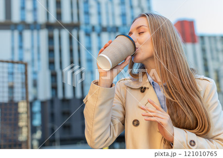 Happy mature businesswoman enjoying morning coffee hot drink and smiling on downtown city street Happy mature businesswoman enjoying morning coffee hot drink and smiling on downtown city street 121010765