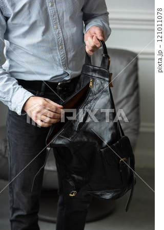 A Stylish and Professional Man Standing with a Bag in a Contemporary Modern Setting 121011078