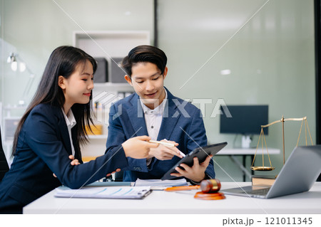 Asian business team and lawyers discussing contract papers sitting at the table. Concepts of law, advice, legal services. Asian business team and lawyers discussing contract papers sitting at the table. Concepts of law, advice, legal services. 121011345