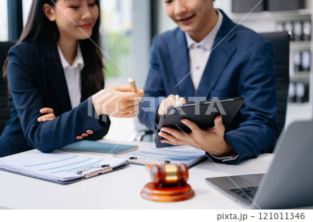Business and lawyers discussing contract papers with brass scale on desk in office. Law, legal services, advice, justice and law Business and lawyers discussing contract papers with brass scale on desk in office. Law, legal services, advice, justice and law 121011346