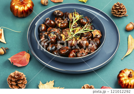 Warm roasted chestnuts served on a plate Warm roasted chestnuts served on a plate 121012292