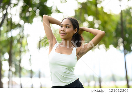 Carefree young woman stretching outdoors, enjoying the fresh air and natural light Carefree young woman stretching outdoors, enjoying the fresh air and natural light 121012803