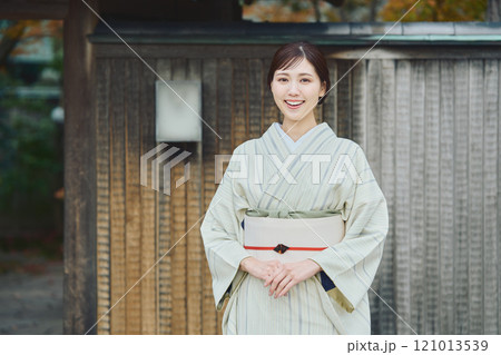 古民家の前に立つ美しい着物女性 121013539