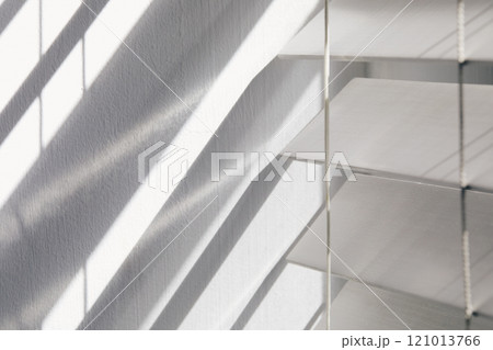Close-up of white window blinds and shadows 121013766