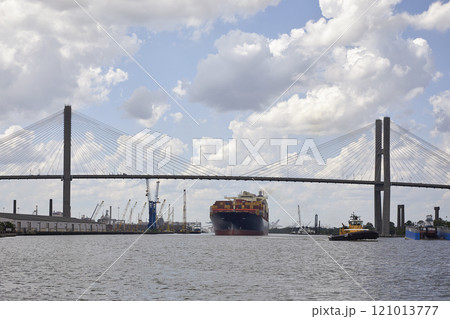 Cargo ship and tugboat under bridge at dock 121013777