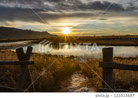 Sunrise over rural spring creek and fields 121013887