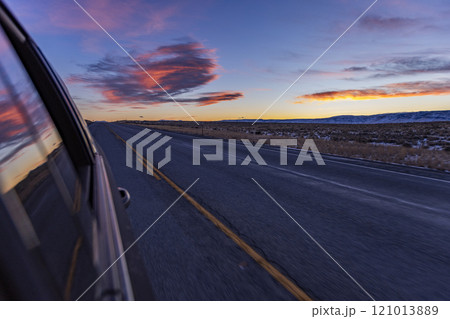 Blurred rural highway seen from moving car at dusk 121013889