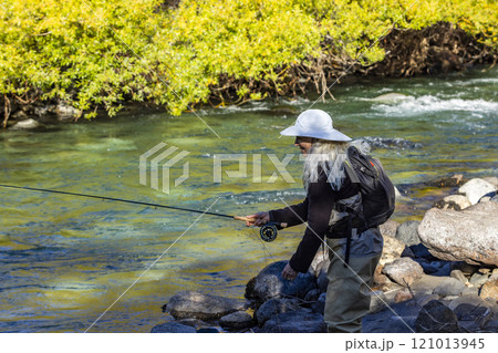 Woman in white hat fly fishing on Traful River 121013945