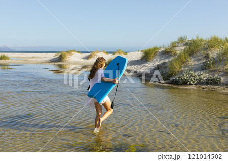 South Africa, Hermanus, Teenage girl walking on beach with body board South Africa, Hermanus, Teenage girl walking on beach with body board 121014502