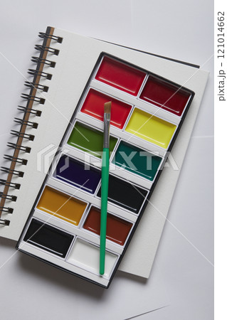 Overhead view of watercolor paints and brush on sketch pad 121014662