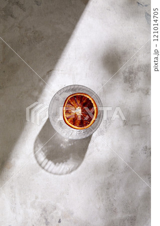Overhead view of glass of Tequila with blood orange slice on marble surface 121014705
