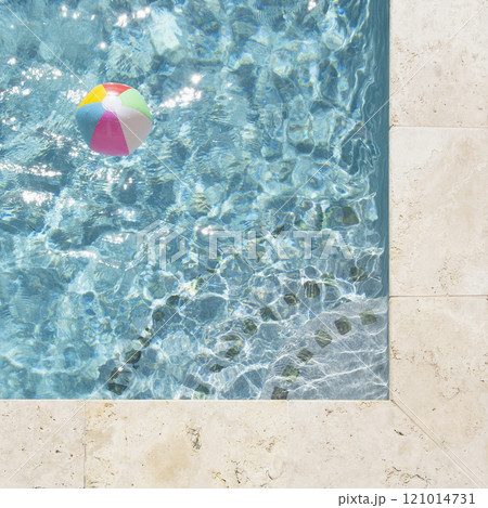 Beach ball floating in swimming pool 121014731