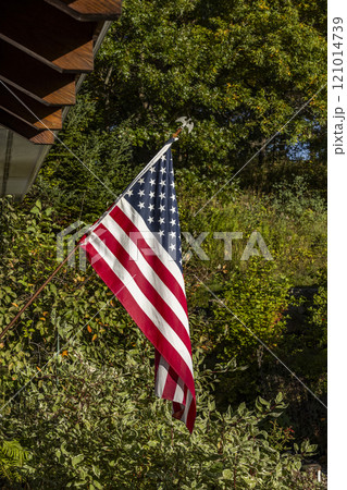 American flag outside house in sunlight 121014739