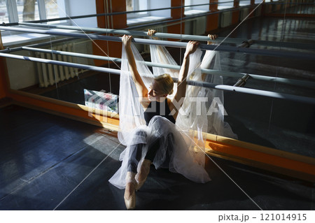 Portrait of ballerina sitting in ballet studio 121014915