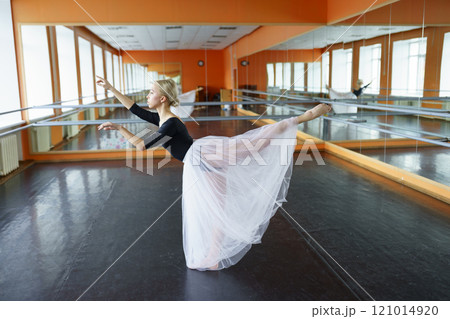 Portrait of ballerina sitting on floor in ballet studio 121014920